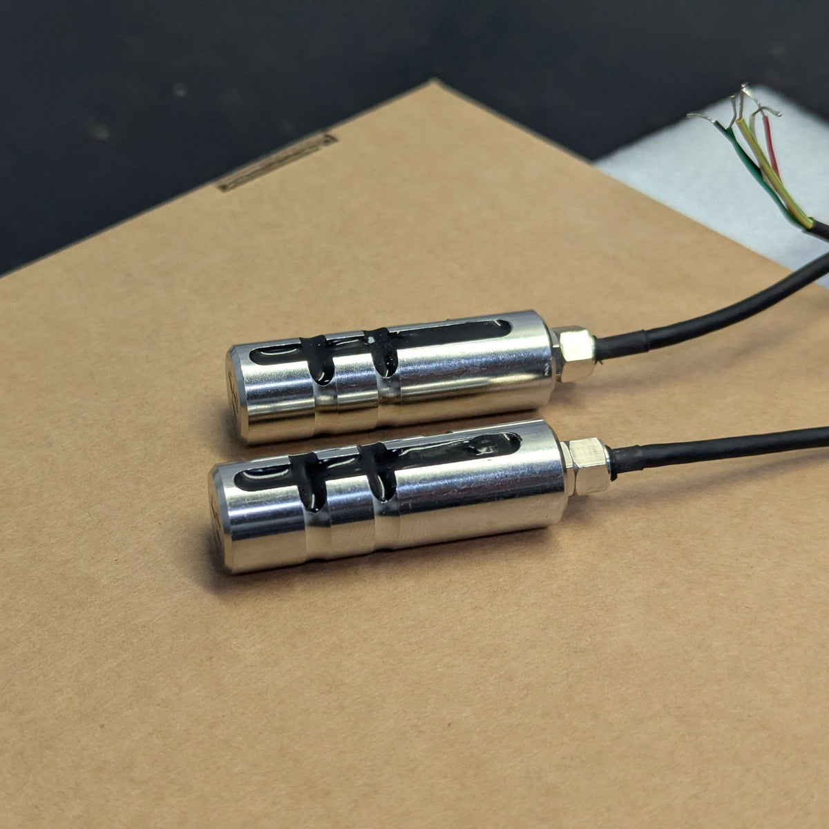 Zwei Miniatur-Lastmessbolzen von octogon mit festem Kabel